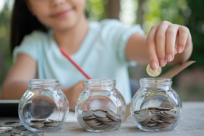 cute-asian-little-girl-playing-with-coins-making-stacks-money-kid-saving-money-into-piggy-bank-into-glass-jar-child-counting-his-saved-coins-children-learning-about-future-concept