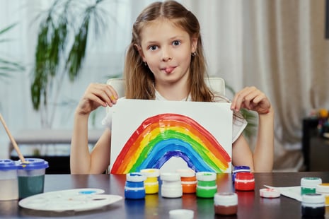 cute-little-girl-holds-painting-with-colorful-rainbow