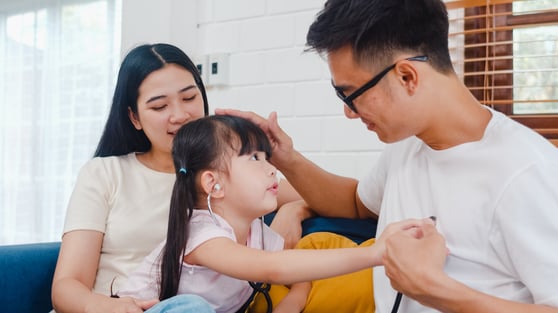 happy-cheerful-asian-family-dad-mom-daughter-playing-funny-game-as-doctor-having-fun-sofa-home