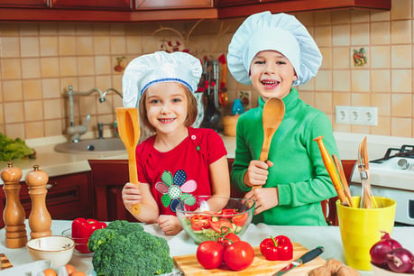 happy-kids-are-preparing-fresh-vegetable-salad-kitchen