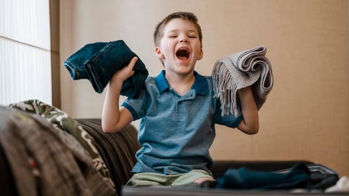 medium-shot-kid-holding-clothes