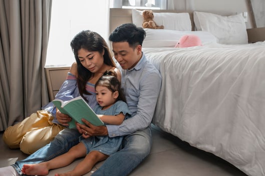 medium-shot-parents-girl-with-book